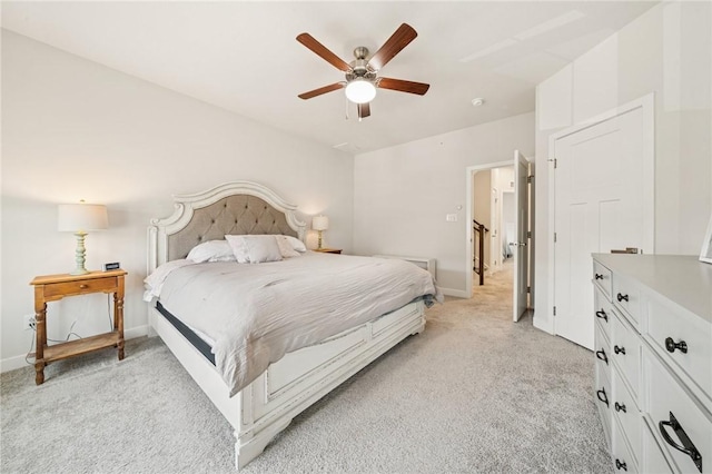 bedroom with a ceiling fan, baseboards, and light carpet