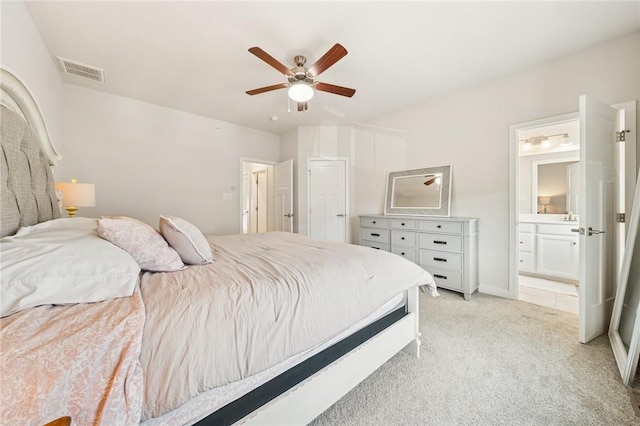 bedroom with light carpet, ensuite bath, visible vents, and ceiling fan