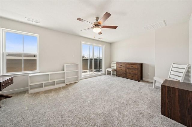 sitting room with visible vents, carpet flooring, and ceiling fan