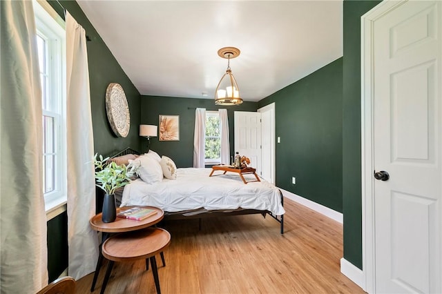 bedroom with light wood finished floors and baseboards