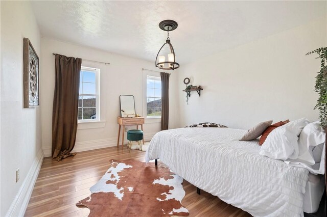 bedroom featuring baseboards and wood finished floors