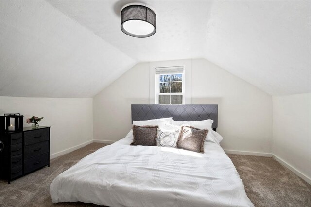 carpeted bedroom with vaulted ceiling and baseboards