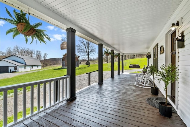 wooden terrace with covered porch and a yard