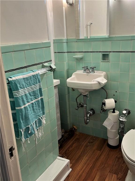 166 N Dithridge St Unit L2, Oakland, PA 15213 - bathroom with wood finished floors, toilet, a sink, tile walls, and wainscoting