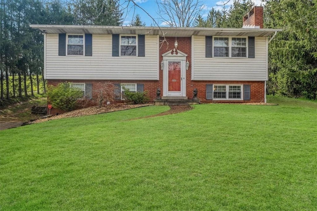 1949 Rostraver Rd, Rostraver, PA 15012 - bi-level home with a chimney, a front lawn, and brick siding