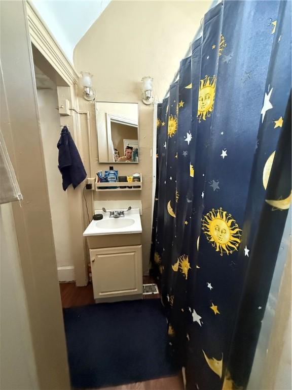 2106 Sarah St, South Side, PA 15203 - full bathroom featuring vaulted ceiling, vanity, and wood finished floors