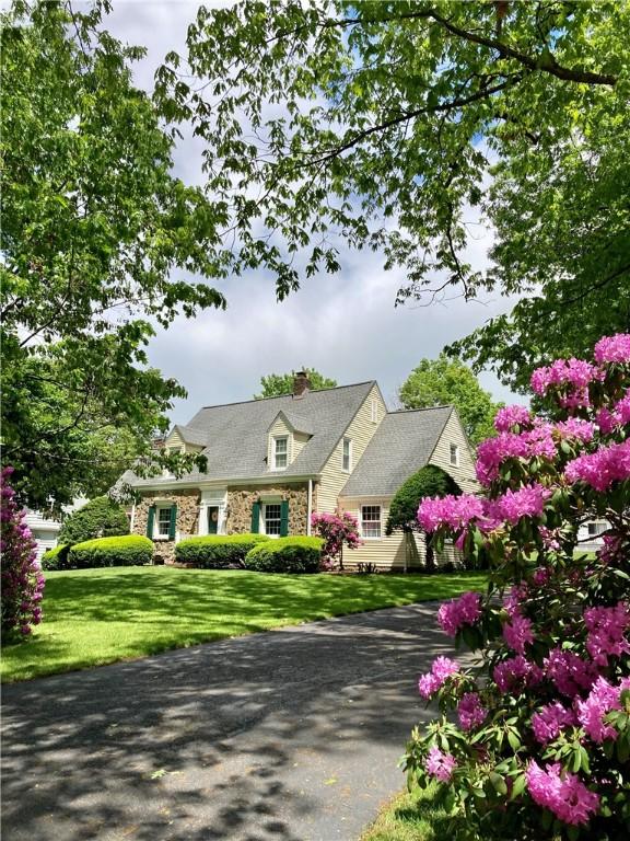 200 E Washington Blvd, Grove City Boro, PA 16127 - cape cod-style house with stone siding, a chimney, and a front lawn