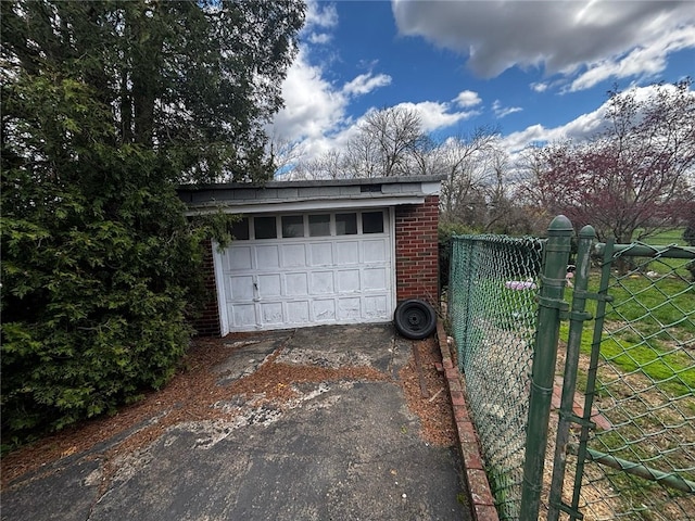 garage with fence and aphalt driveway