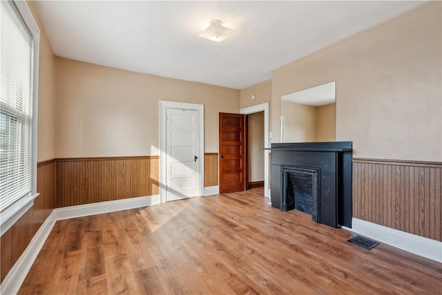 400 Allison Ave, City Of Washington, PA 15301 - unfurnished living room featuring wainscoting, wood finished floors, visible vents, and a fireplace
