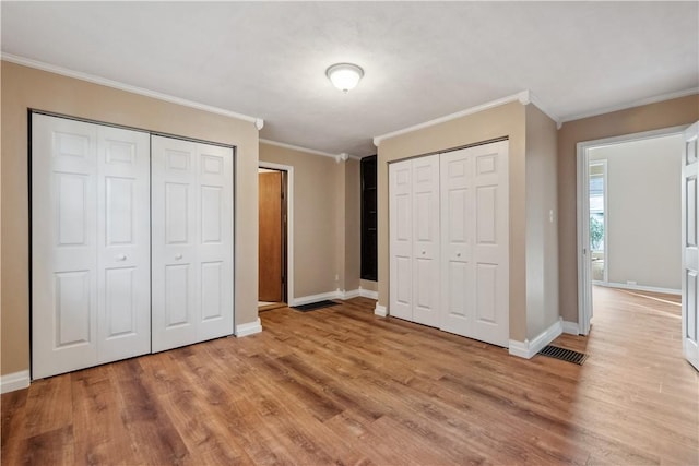 400 Allison Ave, City Of Washington, PA 15301 - unfurnished bedroom featuring visible vents, baseboards, wood finished floors, two closets, and ornamental molding