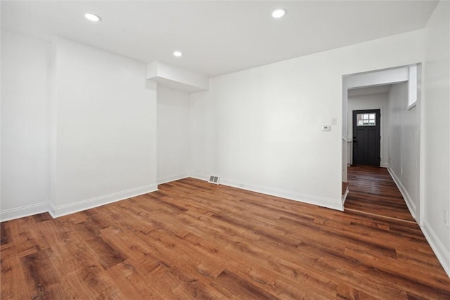 empty room featuring recessed lighting, wood finished floors, visible vents, and baseboards