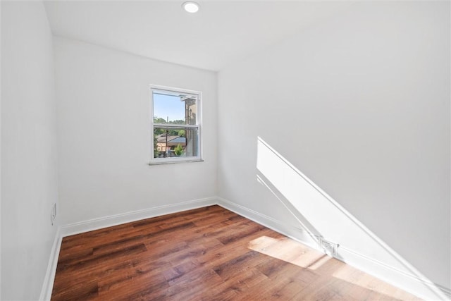 spare room with recessed lighting, wood finished floors, and baseboards