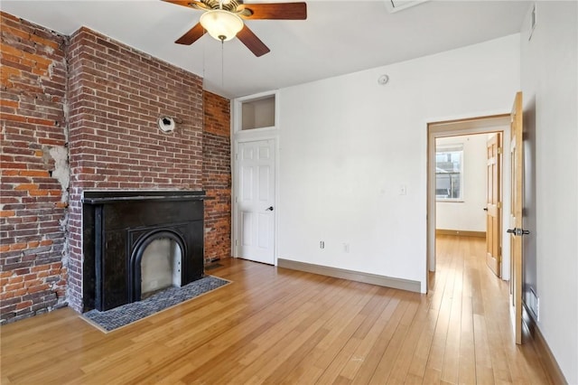 unfurnished living room featuring light wood-type flooring, a ceiling fan, baseboards, and a fireplace