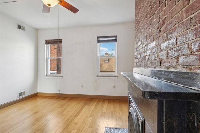unfurnished living room with a ceiling fan, baseboards, visible vents, and light wood finished floors