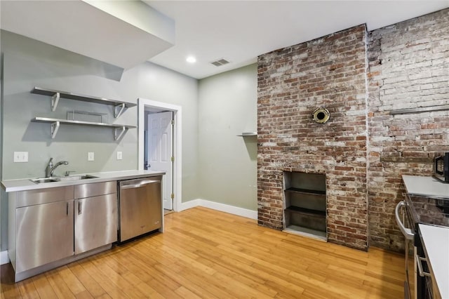 kitchen featuring light wood-style flooring, a sink, baseboards, visible vents, and appliances with stainless steel finishes