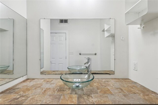 bathroom with visible vents and stone finish flooring