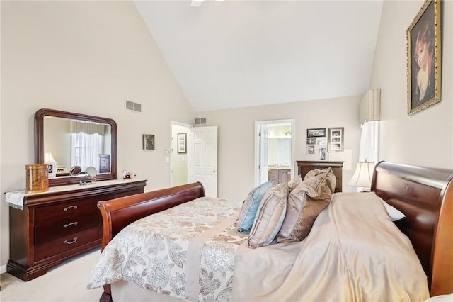 bedroom featuring high vaulted ceiling, connected bathroom, and visible vents