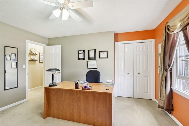 office area featuring baseboards, ceiling fan, and light colored carpet