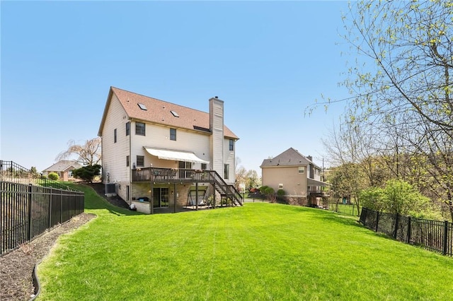 back of property with a wooden deck, a fenced backyard, central air condition unit, a yard, and stairway
