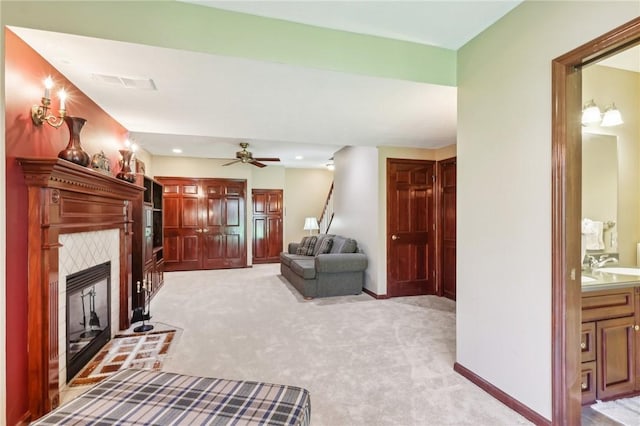 living room with a fireplace, ceiling fan, light carpet, and visible vents