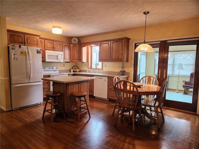 202 Hilltop Dr, Center Twp But, PA 16001 - kitchen with brown cabinetry, white appliances, light countertops, a kitchen bar, and a kitchen island