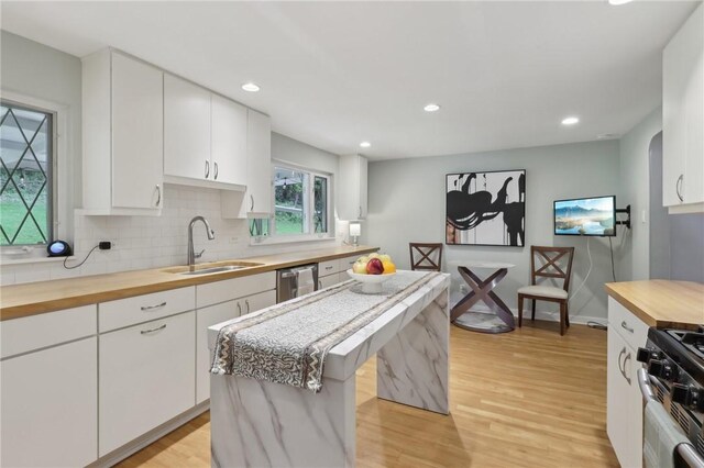 1060 Christopher St, Lawrenceville, PA 15201 - kitchen with wood counters, a sink, light wood finished floors, backsplash, and white cabinets