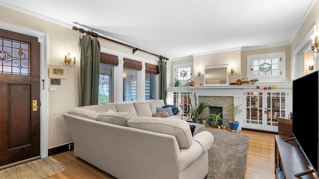 living room featuring a wealth of natural light, crown molding, and wood finished floors