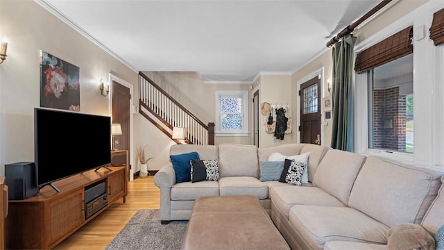 living room with light wood-type flooring, stairs, and ornamental molding