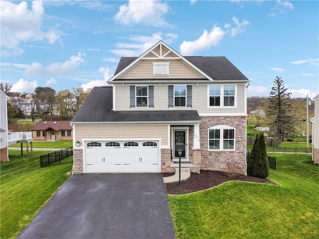 craftsman house featuring a front lawn, fence, stone siding, and driveway