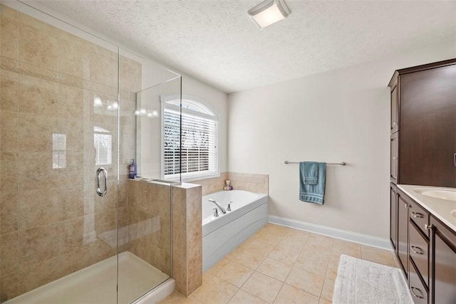 bathroom with a shower stall, tile patterned flooring, a bath, a textured ceiling, and vanity