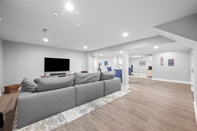 living area featuring wood finished floors, baseboards, and recessed lighting