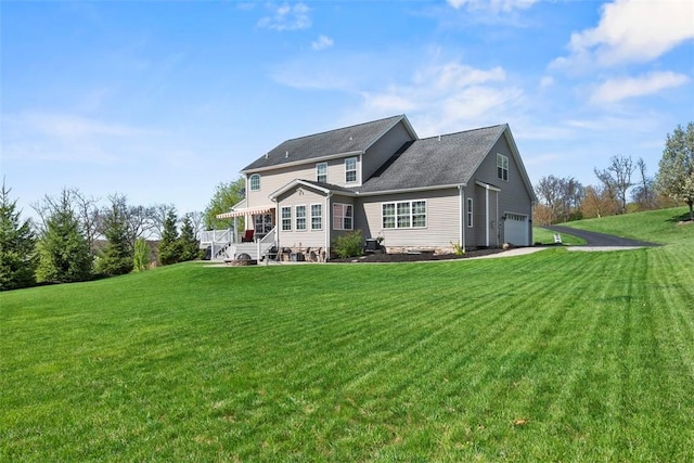back of house with a garage and a lawn
