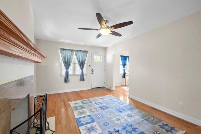 foyer with wood finished floors, visible vents, a ceiling fan, and baseboards