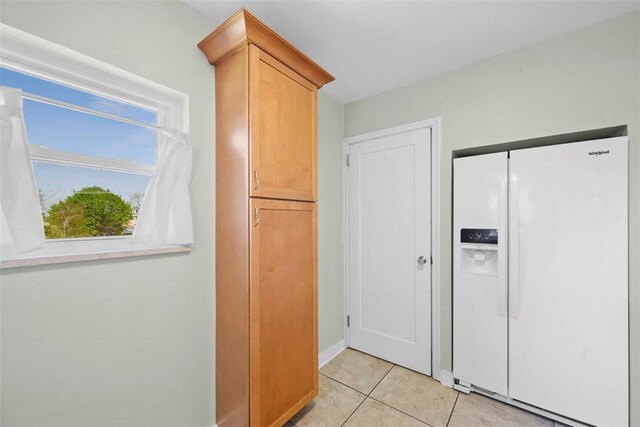 interior space with baseboards and light tile patterned floors