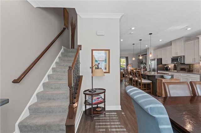 stairs with recessed lighting, wood finished floors, and baseboards