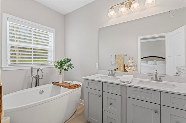 full bath with double vanity, a freestanding tub, and a sink