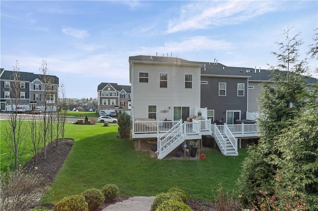 rear view of property with a wooden deck, a lawn, and stairway
