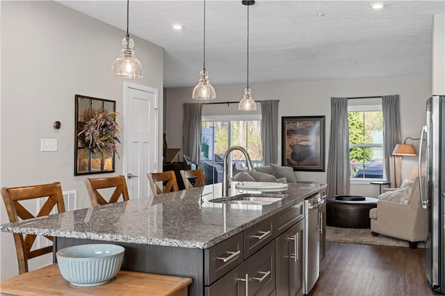 kitchen with open floor plan, a breakfast bar area, and a sink
