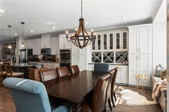 dining space featuring dark wood-type flooring, recessed lighting, and a notable chandelier