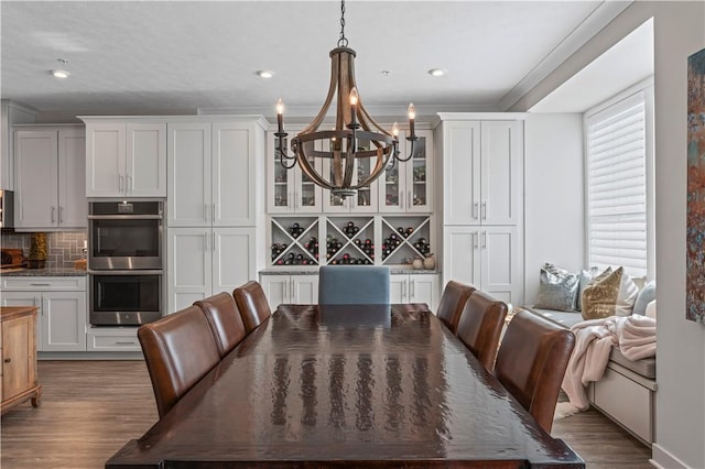 dining room featuring ornamental molding, a notable chandelier, wood finished floors, and recessed lighting