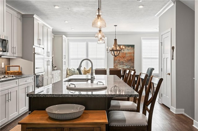 dining room with recessed lighting, an inviting chandelier, ornamental molding, baseboards, and dark wood-style flooring