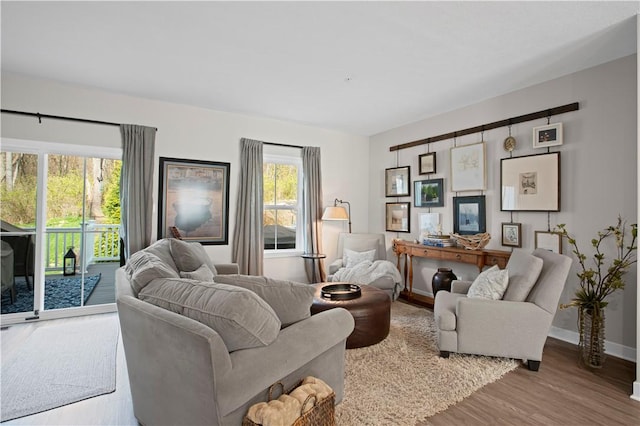 living area with baseboards and wood finished floors