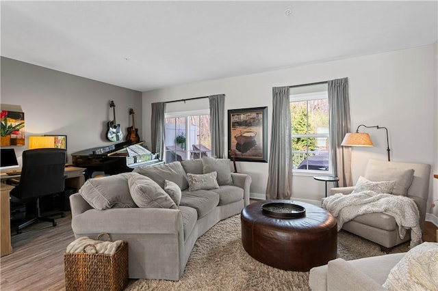 living room with baseboards, light wood finished floors, and plenty of natural light