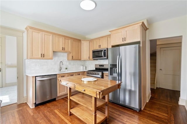 kitchen featuring dark wood finished floors, light brown cabinetry, stainless steel appliances, and a sink