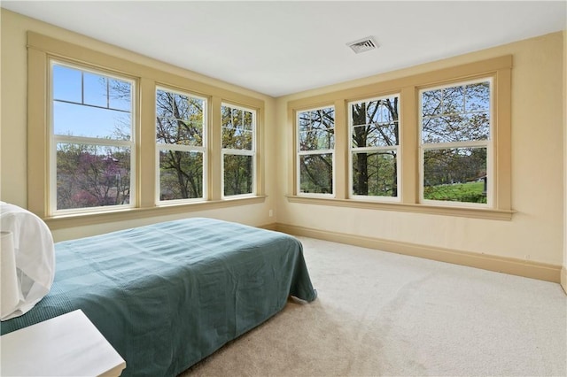 carpeted bedroom featuring baseboards and visible vents