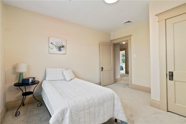 bedroom with visible vents, baseboards, and light carpet