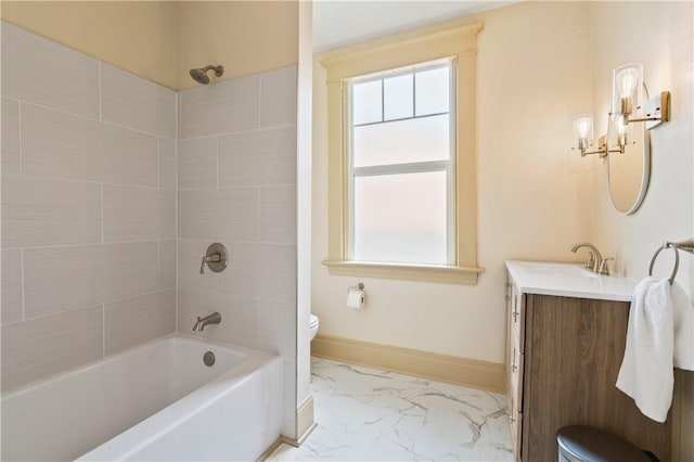 bathroom featuring washtub / shower combination, marble finish floor, toilet, vanity, and baseboards