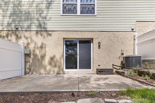 1402 Magnolia Ct, Bethel Park, PA 15102 - view of exterior entry featuring fence, a patio, central AC, and stucco siding