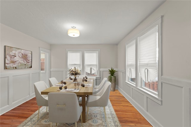 129 S Braddock Ave, Point Breeze, PA 15221 - dining room with wainscoting, a decorative wall, and light wood-type flooring