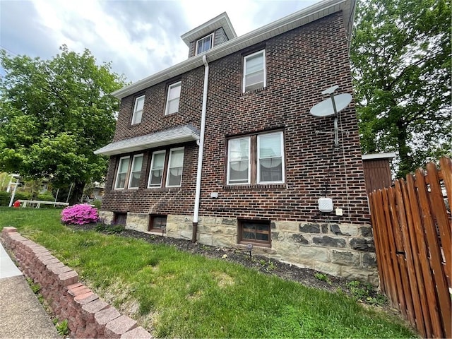 129 S Braddock Ave, Point Breeze, PA 15221 - view of home's exterior featuring a lawn, brick siding, and fence